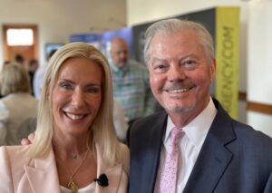 Two smiling adults posing at indoor networking event